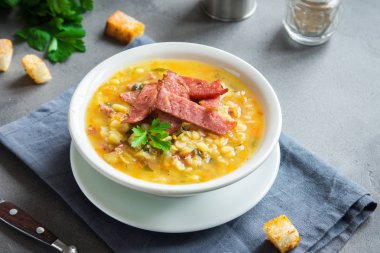 Tütsülenmiş jambon ve gri arka plan üzerinde kruton Split bezelye çorbası. Sağlıklı ev yapımı kalın split çorbası kış öğle yemeği için.