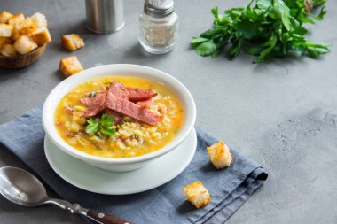 Tütsülenmiş jambon ve gri arka plan üzerinde kruton Split bezelye çorbası. Sağlıklı ev yapımı kalın split çorbası kış öğle yemeği için.