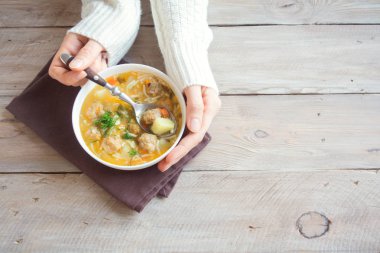 Erkek köfte çorbası kopya alanı ile ahşap arka plan üzerine eller. Ev yapımı köfte çorbası yeme girl (kadın).