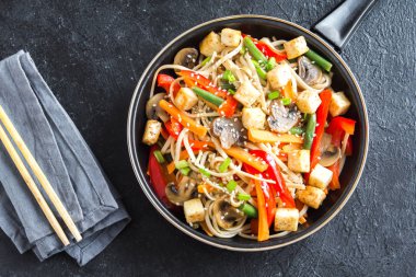 Udon erişte, soya peyniri, mantar ve sebze Fry karıştırın. Asya vegan vejetaryen yemek, yemek, wok siyah arka plan, kopya alanı üzerinde heyecan kızartma.