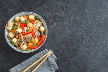 Udon erişte, soya peyniri, mantar ve sebze Fry karıştırın. Asya vegan vejetaryen yemek, yemek, stir fry siyah arka plan, kopya alanı üzerinde.