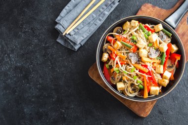 Udon erişte, soya peyniri, mantar ve sebze Fry karıştırın. Asya vegan vejetaryen yemek, yemek, wok siyah arka plan, kopya alanı üzerinde heyecan kızartma.