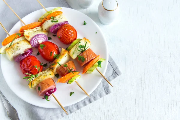 Beyaz plaka, kopya alanı üzerinde taze otlar ile ızgara sebze ve sosis şiş