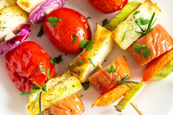 Beyaz plaka üzerinde taze otlar ile ızgara sebze ve sosis şiş