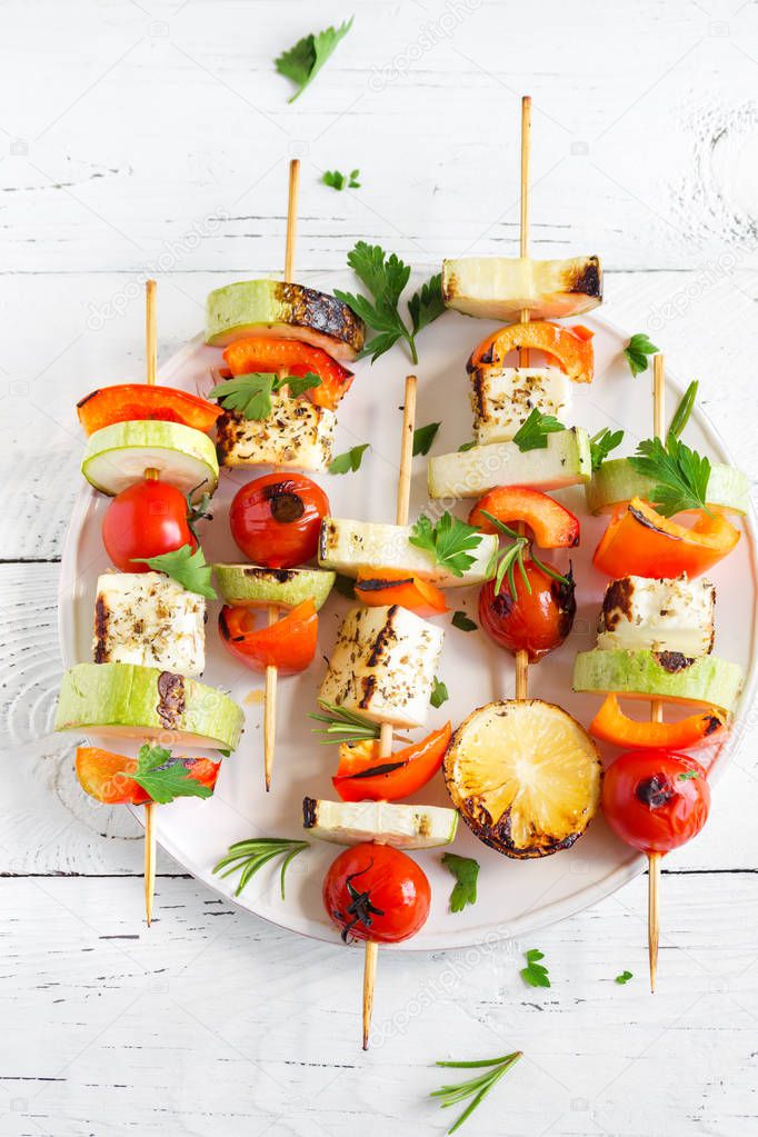 Vegetarian grilling. Vegetarian skewers with halloumi cheese and vegetables on white background, copy space.