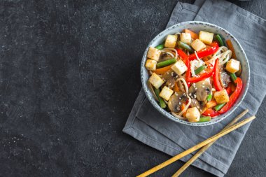 Udon erişte, soya peyniri, mantar ve sebze Fry karıştırın. Asya vegan vejetaryen yemek, yemek, stir fry siyah arka plan, kopya alanı üzerinde.