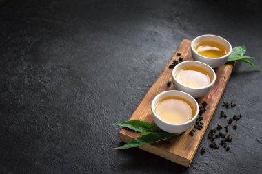 Seramik bardak, Kuru yeşil oolong çay ve çay yaprakları kopya alanı siyah taş masada yeşil çay. 