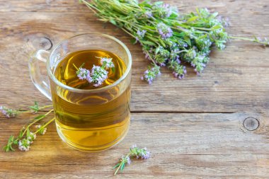 Grup eski ahşap zemin üzerine taze kekik ile sağlıklı bitki çayı. Kekik çay, bitkisel içki.