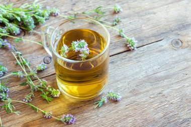 Demet taze kekik ve eski ahşap arka plan üzerinde vintage çay süzgeci ile sağlıklı bitki çayı. Kekik çay, bitkisel içki.