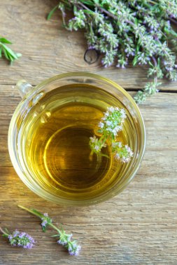 Demet taze kekik ve eski ahşap arka plan üzerinde vintage çay süzgeci ile sağlıklı bitki çayı. Kekik çay, bitkisel içki.