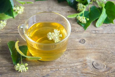 Demet taze ıhlamur çiçek ahşap arka plan üzerinde çay sağlıklı Bitkisel linden. Organik linden çay, bitkisel içki.