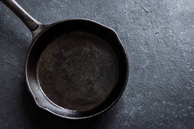Dökme demir tava rustik siyah taş zemin üzerine yakın up - boş siyah kopya alanı ile tavada kızartma tava