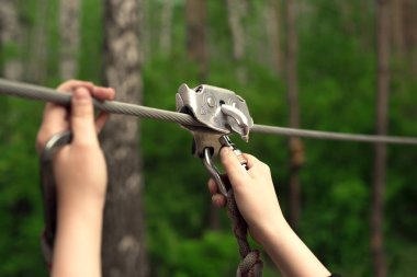 ZIP satırı aktivite. Ormandaki ZIP satırındaki çantanıza holding eller.