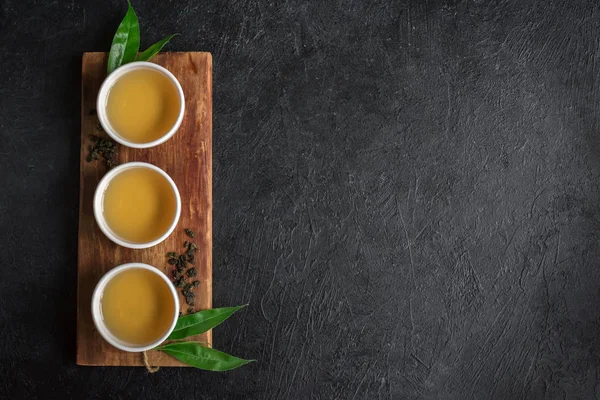 Seramik bardak, Kuru yeşil oolong çay ve çay yaprakları kopya alanı siyah taş masada yeşil çay.