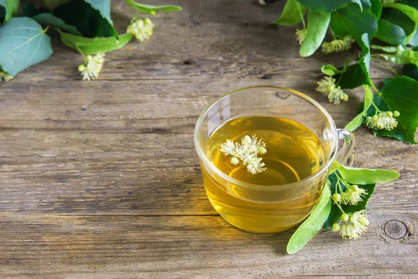 Demet taze ıhlamur çiçek ahşap arka plan üzerinde çay sağlıklı Bitkisel linden. Organik linden çay, bitkisel içki.