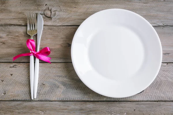 浪漫的餐桌设置与白色板 现代餐具和红丝带在木质背景 顶部视图 复制空间 浪漫晚餐 婚礼理念 — 图库照片