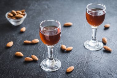 İtalyan likörü Amaretto badem siyah taş arka planda, kopya alanı ile