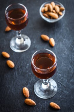 İtalyan likörü Amaretto badem siyah taş arka planda, kopya alanı ile