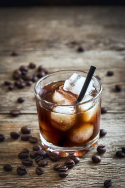 Siyah Rus kokteyl votka ve kahve likörü ile. Ev yapımı alkollü ayyaş siyah Rus iç ahşap zemin kopya alanı üzerine kahve çekirdekleri ile.