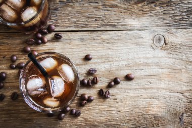 Siyah Rus kokteyl votka ve kahve likörü ile. Ev yapımı alkollü ayyaş siyah Rus iç ahşap zemin üzerine kahve çekirdekleri ile.