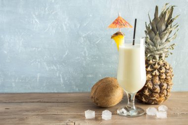 Pina Colada kokteyli ananas ve hindistancevizi üzerinde ahşap arka plan, uzay kopyalayın. Yaz tropikal lezzetli kokteyl.