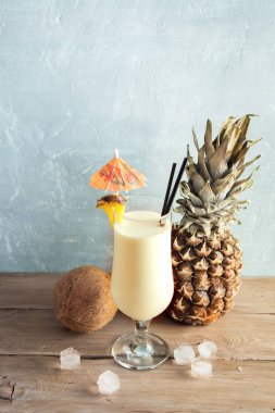 Pina Colada kokteyli ananas ve hindistancevizi üzerinde ahşap arka plan, uzay kopyalayın. Yaz tropikal lezzetli kokteyl.