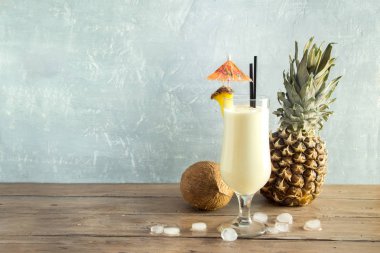 Pina Colada kokteyli ananas ve hindistancevizi üzerinde ahşap arka plan, uzay kopyalayın. Yaz tropikal lezzetli kokteyl.