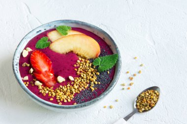 Acai smoothie kaseyle chia tohum, meyve, meyve (çilek) ve arı polen sağlıklı vegan vejetaryen diyet çiğ kahvaltı için. Kahvaltı Smoothie kase beyaz arka plan üzerinde.