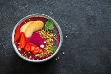 Acai smoothie kaseyle chia tohum, meyve, meyve (çilek) ve arı polen sağlıklı vegan vejetaryen diyet çiğ kahvaltı için. Güler yüzlü kase siyah arka plan üzerine kahvaltı, alanı Kopyala.