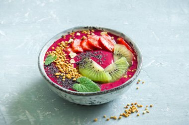 Acai smoothie kaseyle chia tohum, meyve, meyve (çilek) ve arı polen sağlıklı vegan vejetaryen diyet çiğ kahvaltı için. Güler yüzlü kase beyaz zemin üzerine kahvaltı, alanı Kopyala.