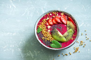 Acai smoothie kaseyle chia tohum, meyve, meyve (çilek) ve arı polen sağlıklı vegan vejetaryen diyet çiğ kahvaltı için. Güler yüzlü kase beyaz zemin üzerine kahvaltı, alanı Kopyala.