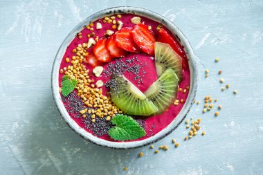 Acai smoothie kaseyle chia tohum, meyve, meyve (çilek) ve arı polen sağlıklı vegan vejetaryen diyet çiğ kahvaltı için. Güler yüzlü kase beyaz zemin üzerine kahvaltı, alanı Kopyala.