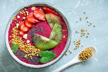 Acai smoothie kaseyle chia tohum, meyve, meyve (çilek) ve arı polen sağlıklı vegan vejetaryen diyet çiğ kahvaltı için. Güler yüzlü kase beyaz zemin üzerine kahvaltı, alanı Kopyala.