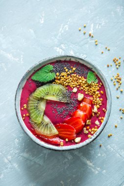 Acai smoothie kaseyle chia tohum, meyve, meyve (çilek) ve arı polen sağlıklı vegan vejetaryen diyet çiğ kahvaltı için. Güler yüzlü kase beyaz zemin üzerine kahvaltı, alanı Kopyala.