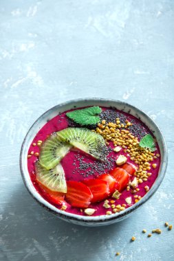 Acai smoothie kaseyle chia tohum, meyve, meyve (çilek) ve arı polen sağlıklı vegan vejetaryen diyet çiğ kahvaltı için. Güler yüzlü kase beyaz zemin üzerine kahvaltı, alanı Kopyala.