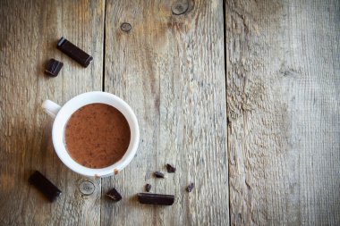 Sıcak çikolata ve çikolata parçaları rustik ahşap arka plan üzerinde. Ev yapımı sıcak çikolata içmek sonbahar ve kış tatilleri için.