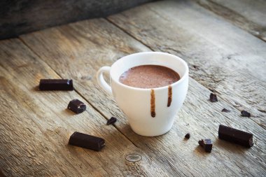 Sıcak çikolata ve çikolata parçaları rustik ahşap arka plan üzerinde. Ev yapımı sıcak çikolata içmek sonbahar ve kış tatilleri için.