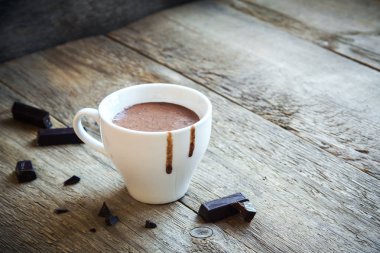 Sıcak çikolata ve çikolata parçaları rustik ahşap arka plan üzerinde. Ev yapımı sıcak çikolata içmek için Noel ve kış tatil.