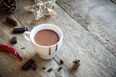 Biber ve rustik ahşap arka plan üzerinde çikolata parçaları ile sıcak çikolata. Ev yapımı sıcak çikolata içmek için Noel ve kış tatil.