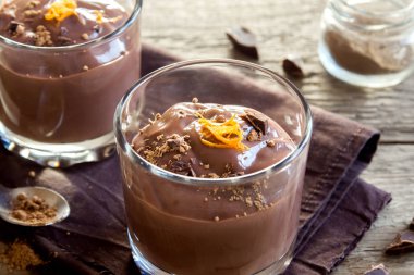 Çikolatalı mus ahşap arka plan yakın up - lezzetli ev yapımı çikolatalı puding üzerinde bardaklarda portakal lezzet ile tepesinde