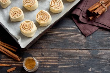 Rulo tarçın veya cinnabon, ev yapımı tarifi çiğ hamur hazırlık tatlı geleneksel tatlı çörekler pasta yemek. Uzay Gıda ingridients rulo tarçın, ahşap masa üzerinde düz lay için kopyalama.
