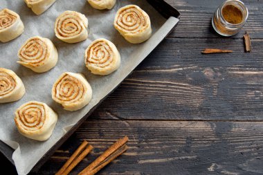 Rulo tarçın veya cinnabon, ev yapımı tarifi çiğ hamur hazırlık tatlı geleneksel tatlı çörekler pasta yemek. Uzay Gıda ingridients rulo tarçın, ahşap masa üzerinde düz lay için kopyalama.