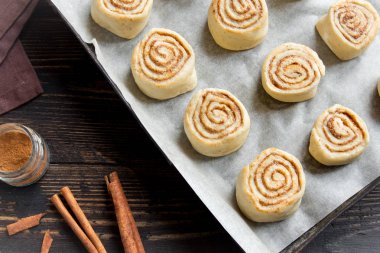 Rulo tarçın veya cinnabon, ev yapımı tarifi çiğ hamur hazırlık tatlı geleneksel tatlı çörekler pasta yemek. Uzay Gıda ingridients rulo tarçın, ahşap masa üzerinde düz lay için kopyalama.