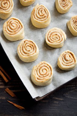 Rulo tarçın veya cinnabon, ev yapımı tarifi çiğ hamur hazırlık tatlı geleneksel tatlı çörekler pasta yemek. Uzay Gıda ingridients rulo tarçın, ahşap masa üzerinde düz lay için kopyalama.