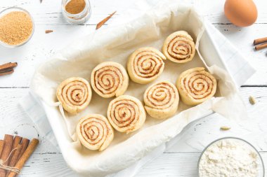 Rulo tarçın veya cinnabon, ev yapımı tarifi çiğ hamur hazırlık tatlı geleneksel tatlı çörekler pasta yemek. Gıda ingridients rulo tarçın için düz beyaz açayım.