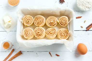 Rulo tarçın veya cinnabon, ev yapımı tarifi çiğ hamur hazırlık tatlı geleneksel tatlı çörekler pasta yemek. Gıda ingridients rulo tarçın için düz beyaz açayım.