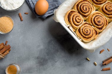 Rulo tarçın veya Cinnabon, ev yapımı tarifi hazırlık tatlı geleneksel tatlı çörekler pasta yemek. Gri beton masaya yiyecek ingridients için tarçın rulo.