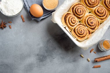 Rulo tarçın veya Cinnabon, ev yapımı tarifi hazırlık tatlı geleneksel tatlı çörekler pasta yemek. Gri beton masaya yiyecek ingridients için tarçın rulo.