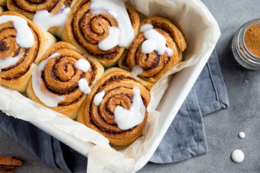 Rulo tarçın veya Cinnabon krema soslu ev yapımı tarifi hazırlık tatlı geleneksel tatlı çörekler pasta yemek. Gri beton masaya yiyecek ingridients için tarçın rulo.