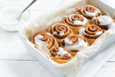 Rulo tarçın veya Cinnabon krema soslu ev yapımı tarifi hazırlık tatlı geleneksel tatlı çörekler pasta yemek. Beyaz masaya yiyecek ingridients için tarçın rulo.